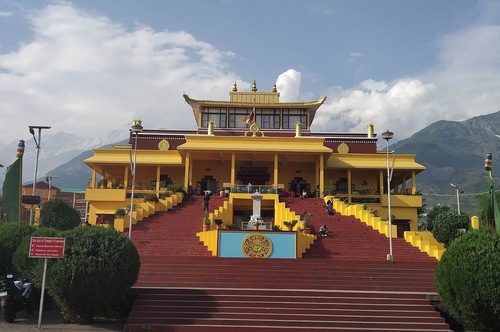 Yellow and red Gyuto Monastery with its grand staircase and mountains behind, Sidhbari