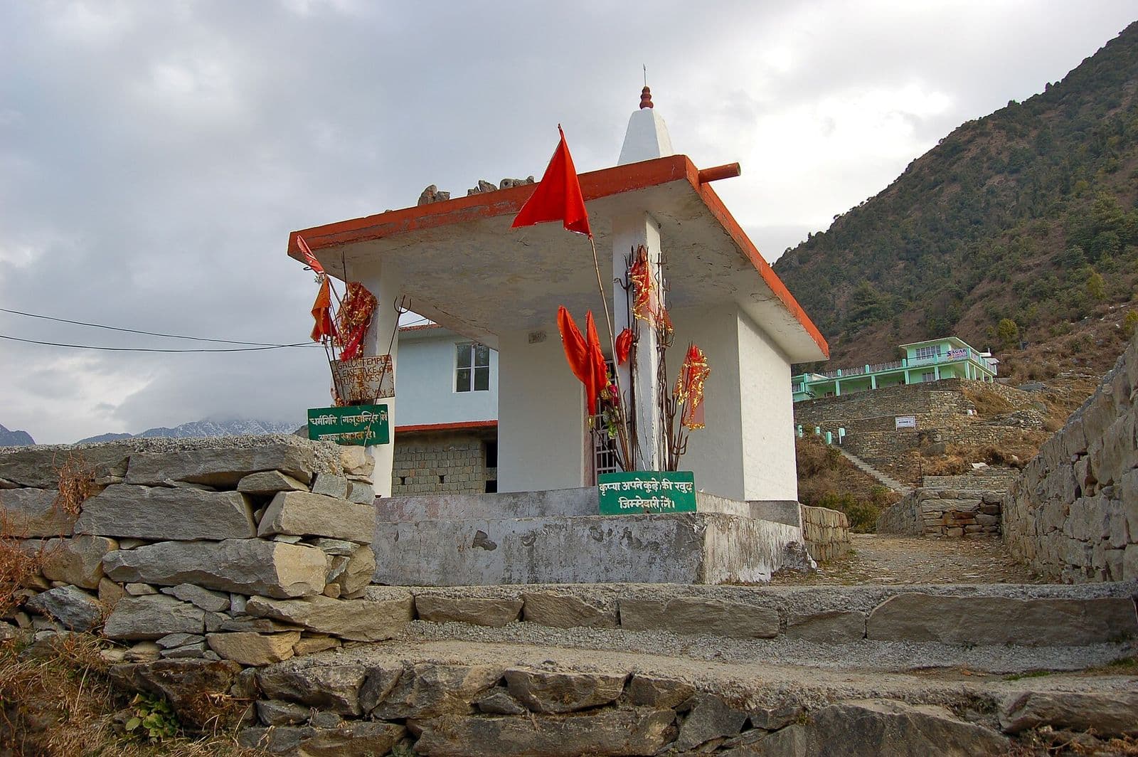 Gallu Devi temple with saffron flags on the stone-paved trail above Dharamkot, on the way to Triund