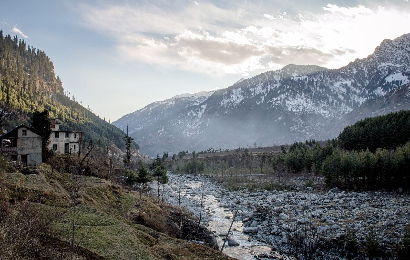 The Beas valley near Manali in late December, with snow on the surrounding peaks and pine forest on the slopes