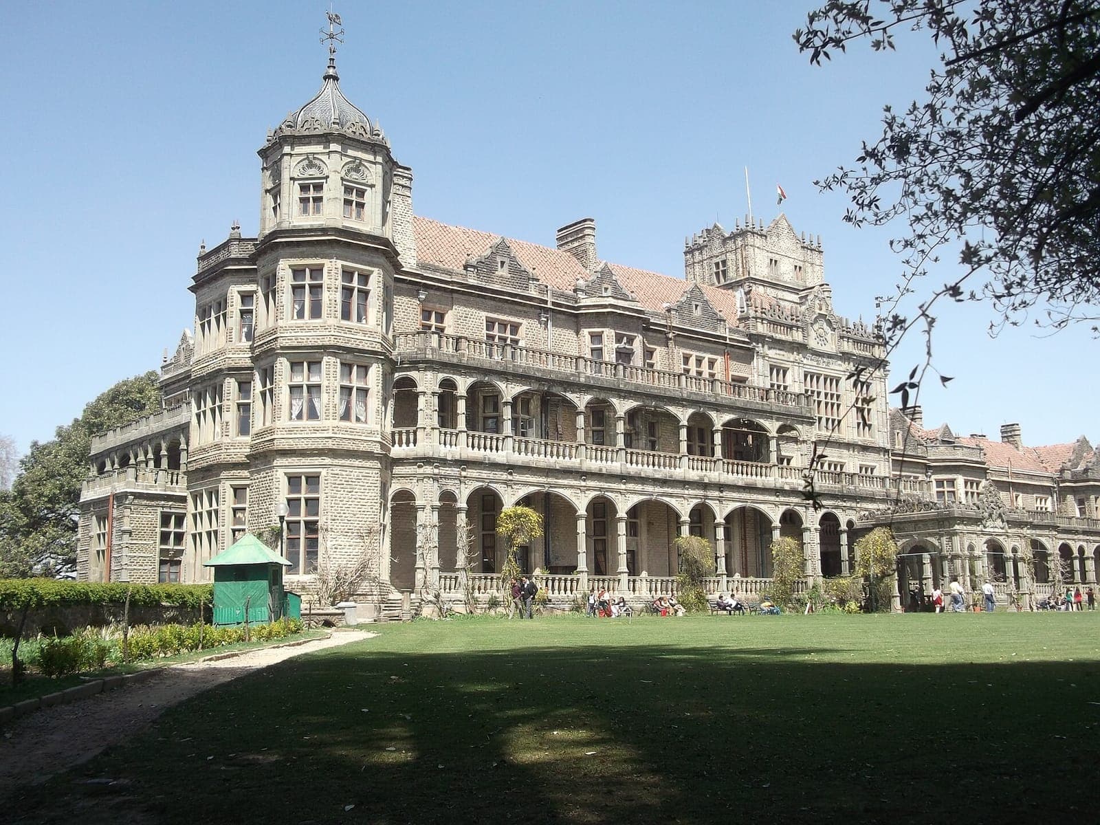 The Viceregal Lodge (Rashtrapati Niwas) in Shimla, a grey stone building with towers behind a green lawn