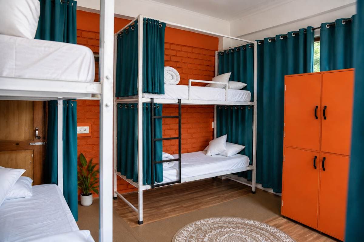 Dorm with bunk beds, curtains and lockers at Loopin McLeodganj