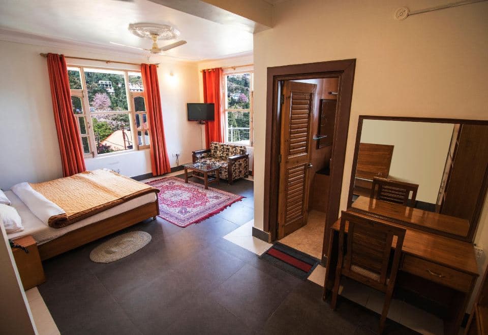 Room with bed and sitting area at The Lodge Dharamkot