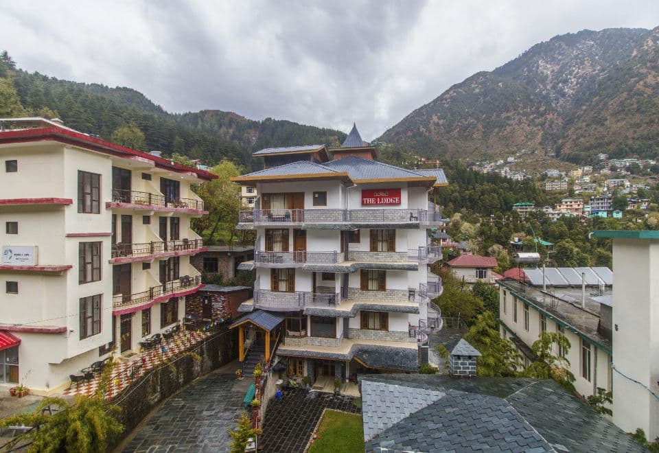 The Lodge Dharamkot hotel building with sign, set among the Dharamkot hillside and mountains