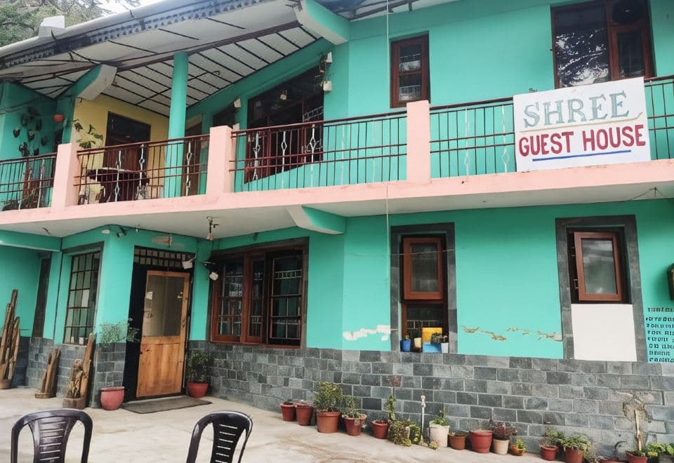 Turquoise front of Shree Guest House with its sign and potted plants, just above the Main Square, McLeod Ganj