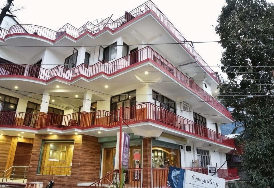 Hotel Akash, a white building with red balcony railings on Jogiwara Road, McLeod Ganj