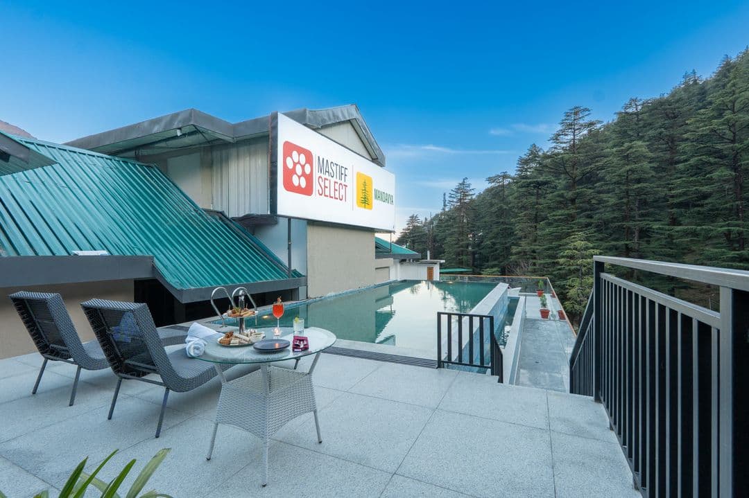 Pool deck with Mastiff Select signage at Mandavya, Dharamkot