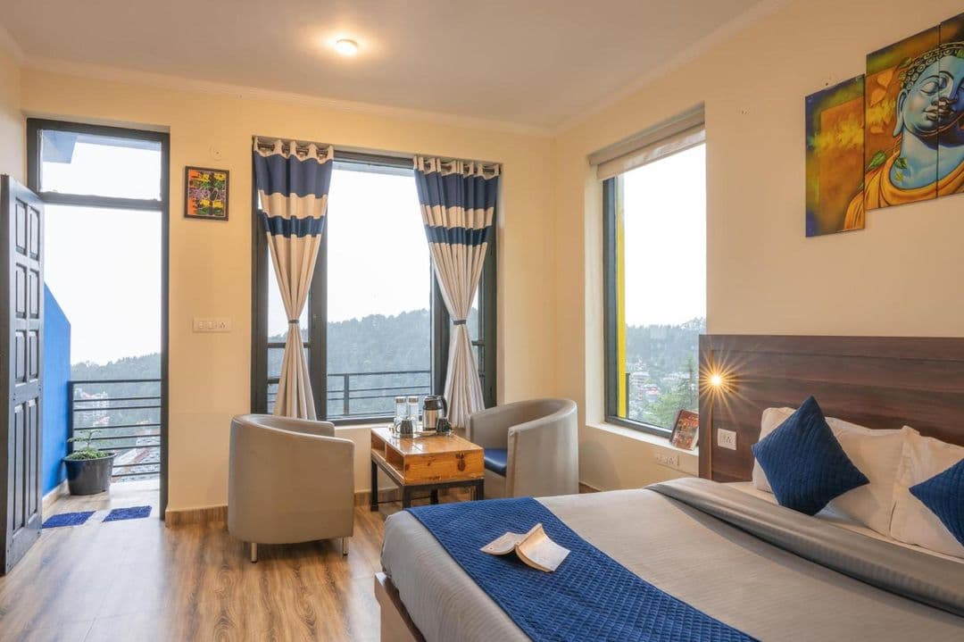 Double room with balcony door and mountain view at Shalom Backpackers Dharamkot