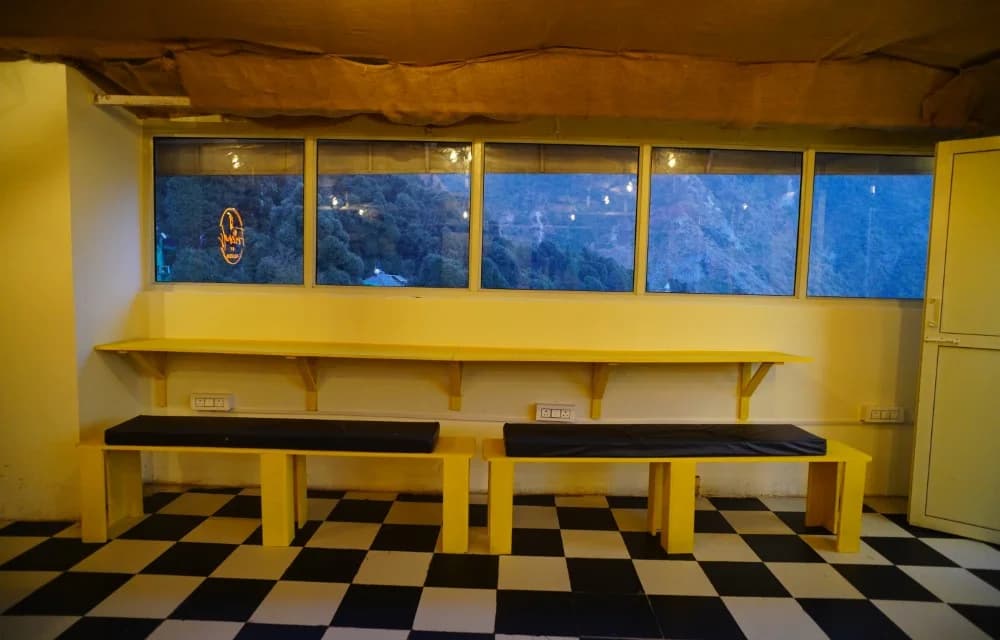 Window counter with bench seating looking out across the Bhagsu valley at dusk
