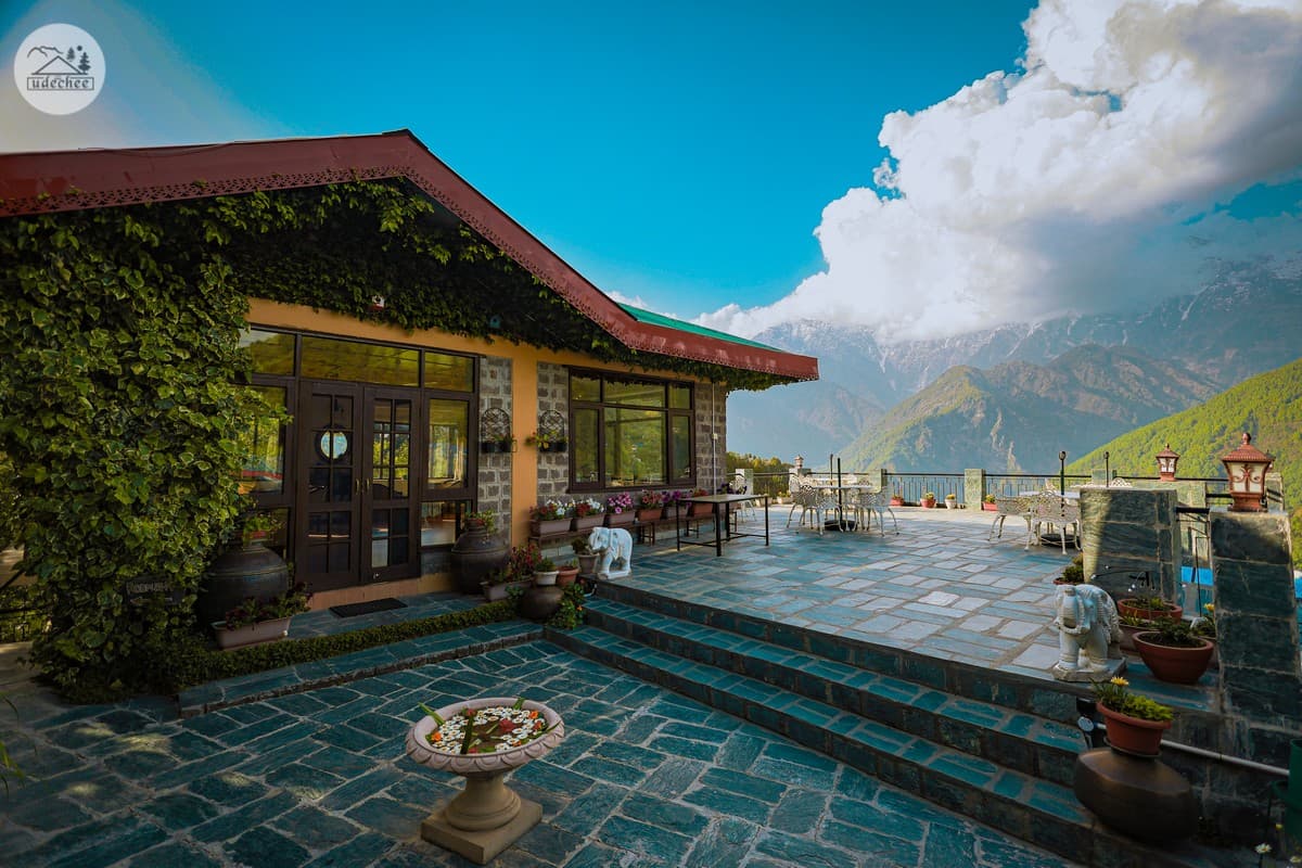 Udechee Huts restaurant building and stone terrace facing the Dhauladhar, Naddi
