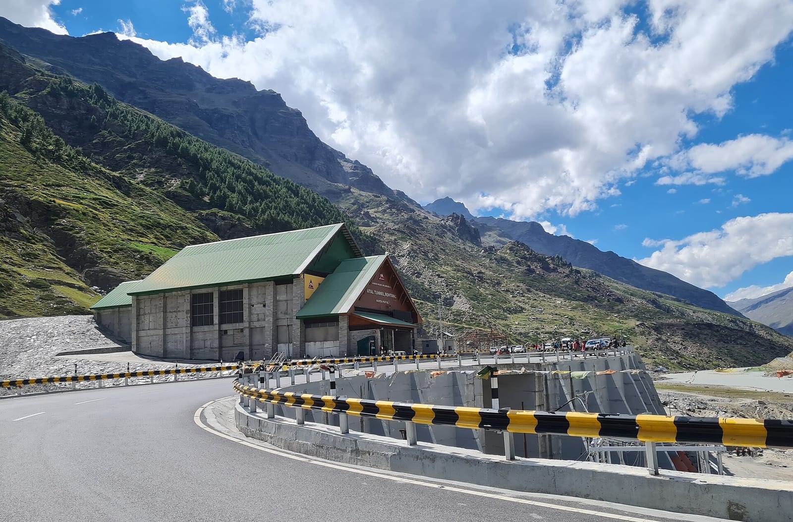 Portal building of the Atal Tunnel, Rohtang, with the curving approach road and bare mountains on a clear day