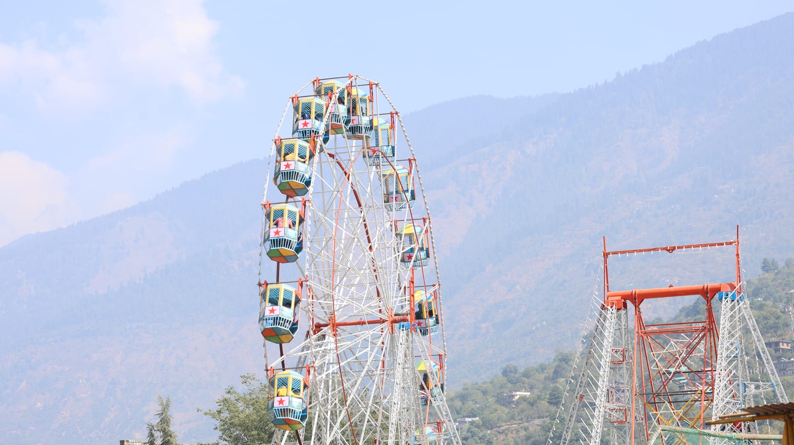 Giant wheel at the Kullu Dussehra fair with Himalayan hills behind, Himachal Pradesh