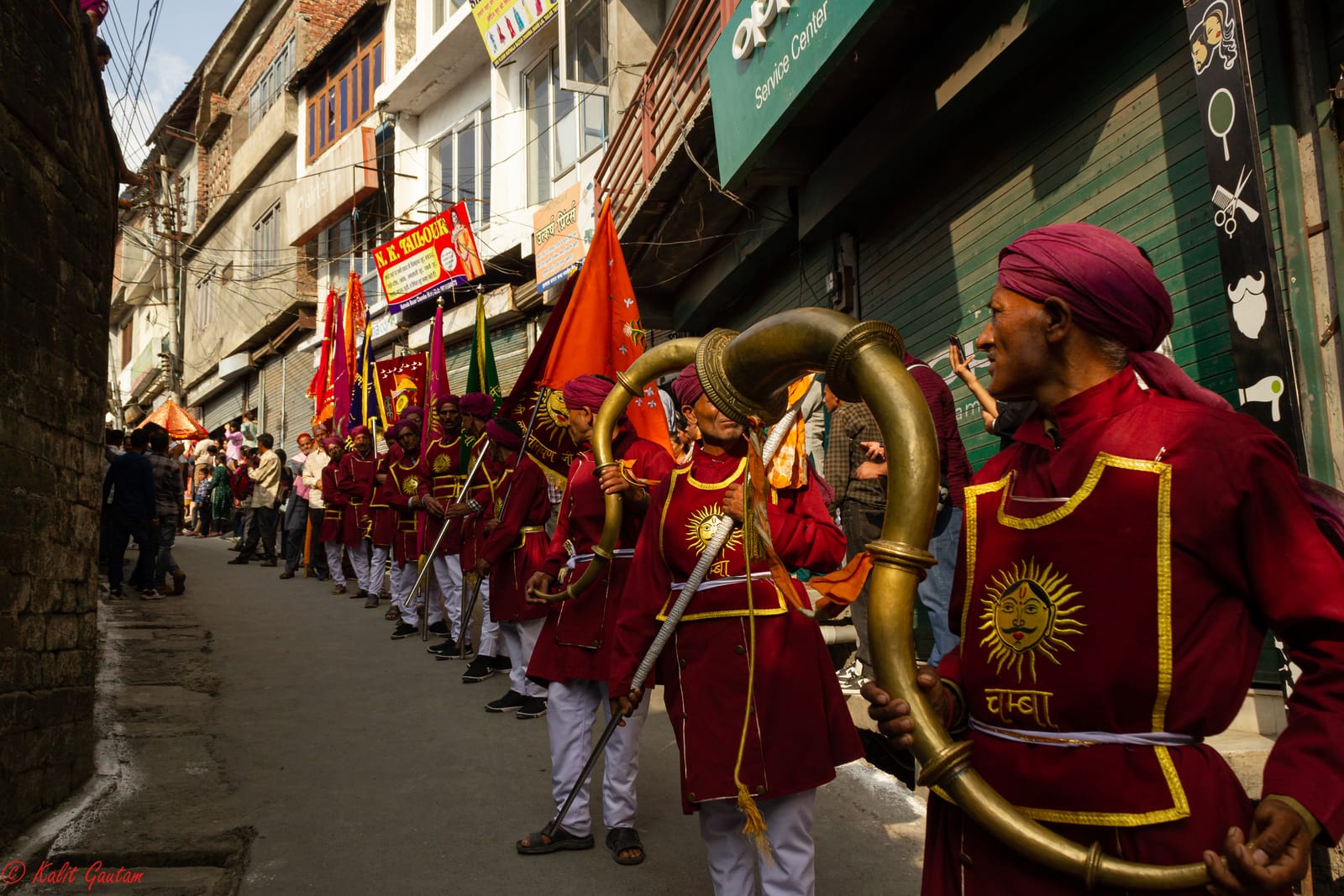 Musicians in red with narsingha horns leading the Minjar fair procession through Chamba, Himachal Pradesh