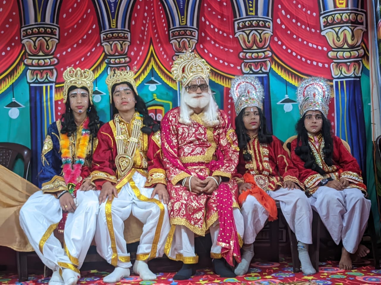 Ramlila actors in costume as King Dasharatha and his four sons on a painted stage, at a village Ramlila in Uttarakhand