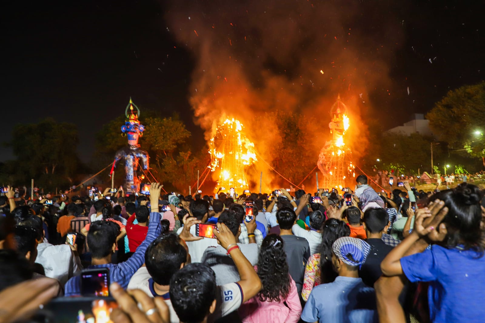 Crowd filming as Dussehra effigies go up in flames with fireworks at night